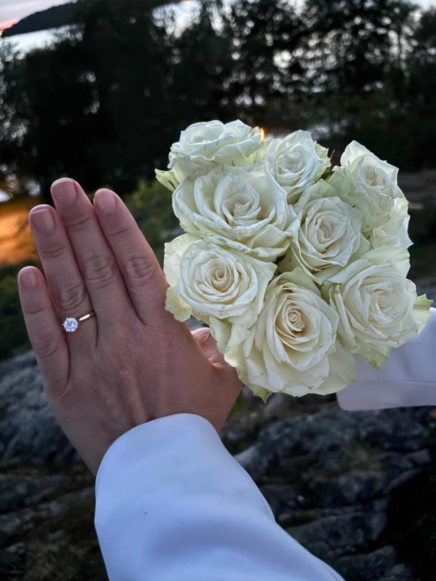 Ringen på Amandas hand vid en bukett vita rosor