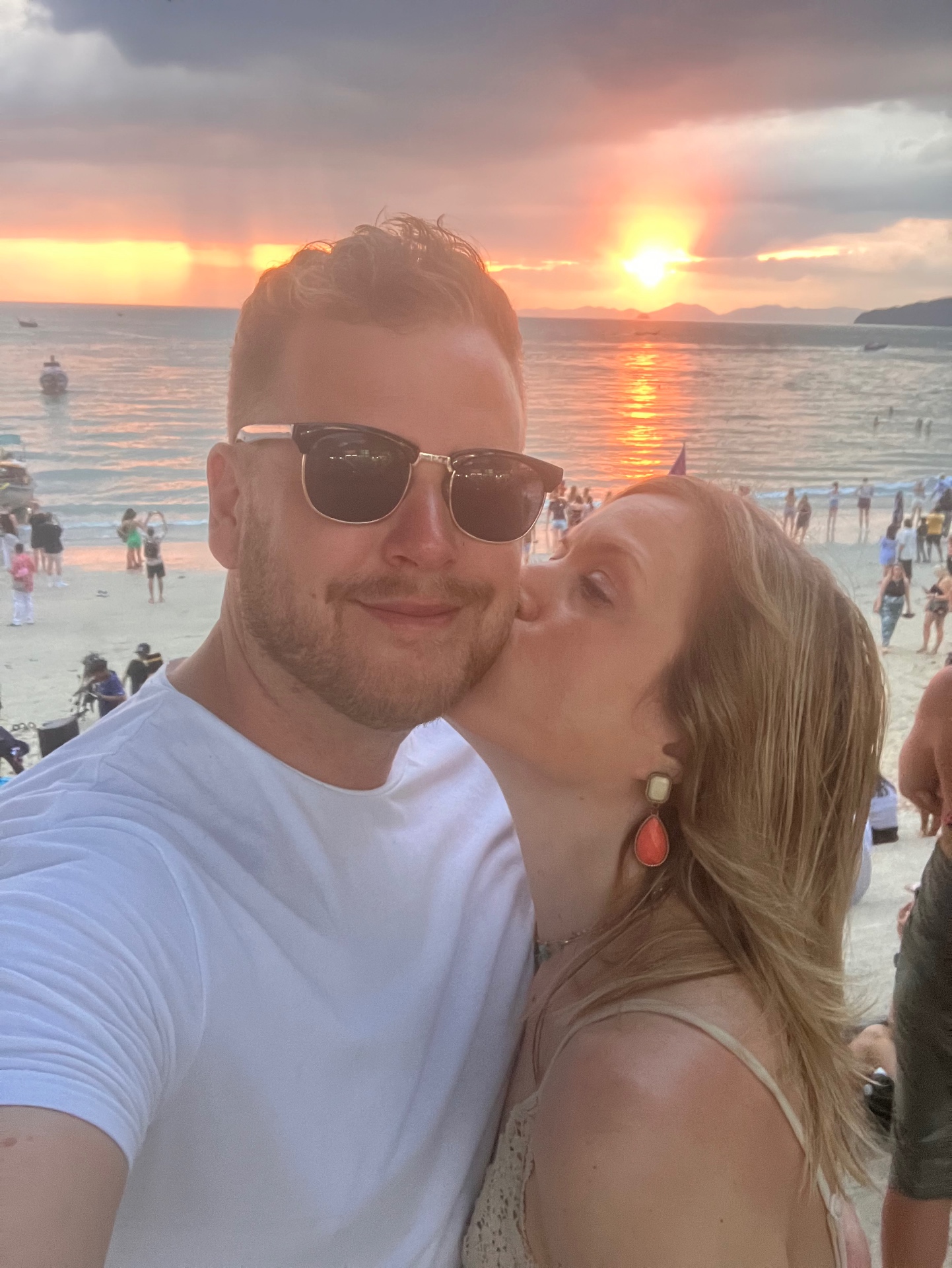 Amanda pussar Simon på kinden vid stranden i solnedgången