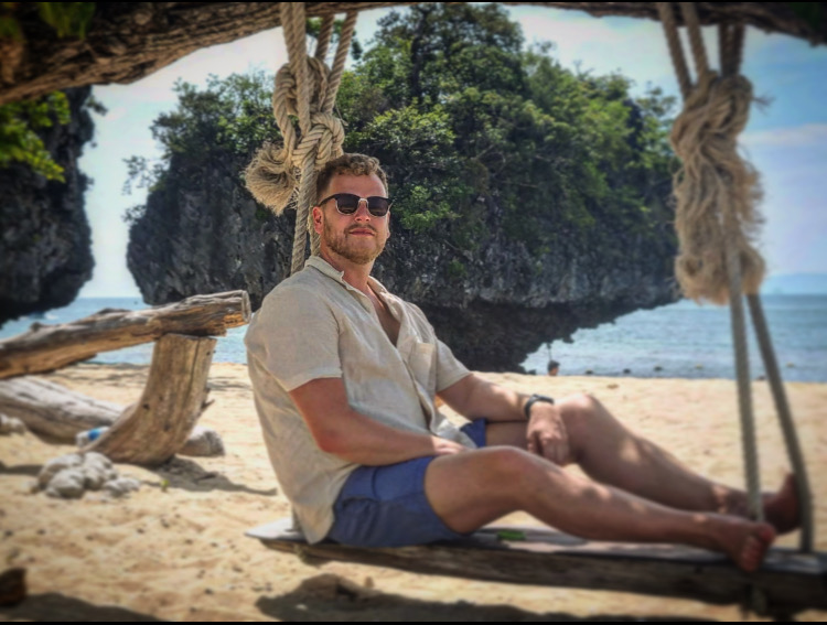 Simon på en gunga vid stranden